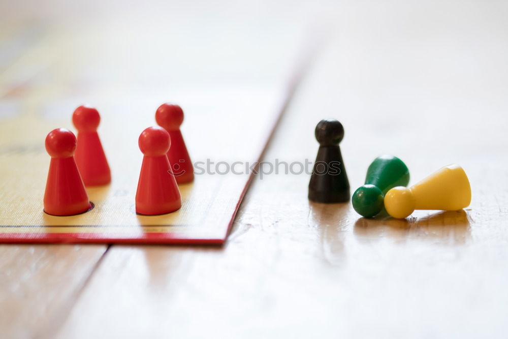 Similar – Three game pieces in German colours stand in front of a large group of game pieces in black, red, gold