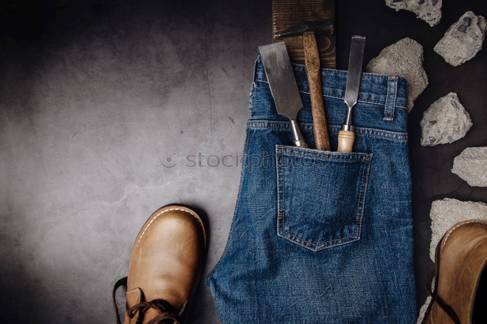 Detail of worn blue jeans and brown shoes