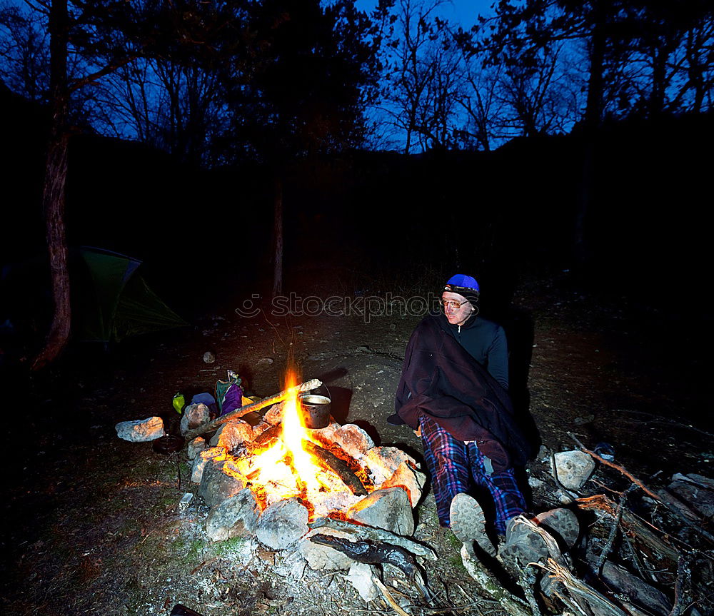 Similar – Man lights a fire in the fireplace in nature at night