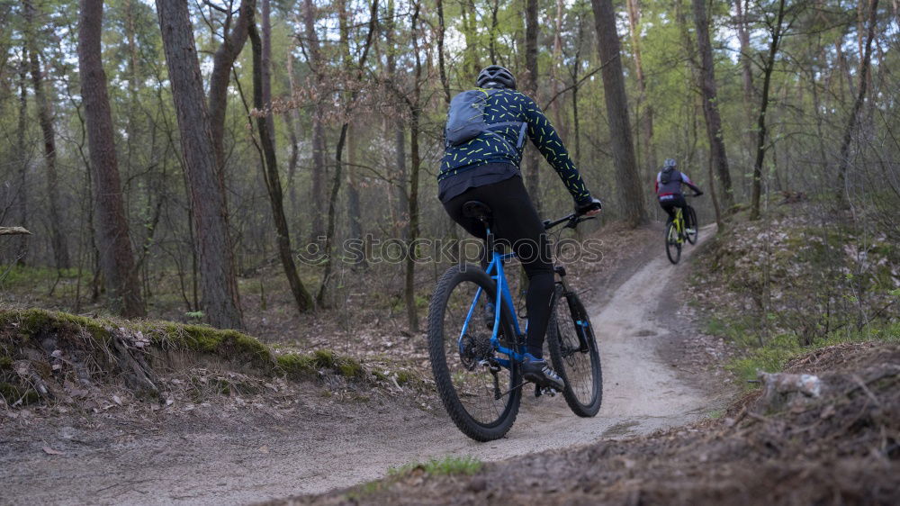 Similar – Biker in Jeans und kariertem Hemd springt mit dem Fahrrad die MTB-Strecke hinunter