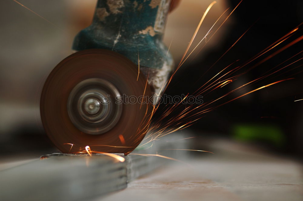 Similar – Unrecognizable worker cutting metal in garage