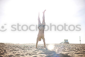 Similar – Young female athlete doing exercise on beach