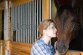 Similar – Young dark-haired curly woman with horse in stable