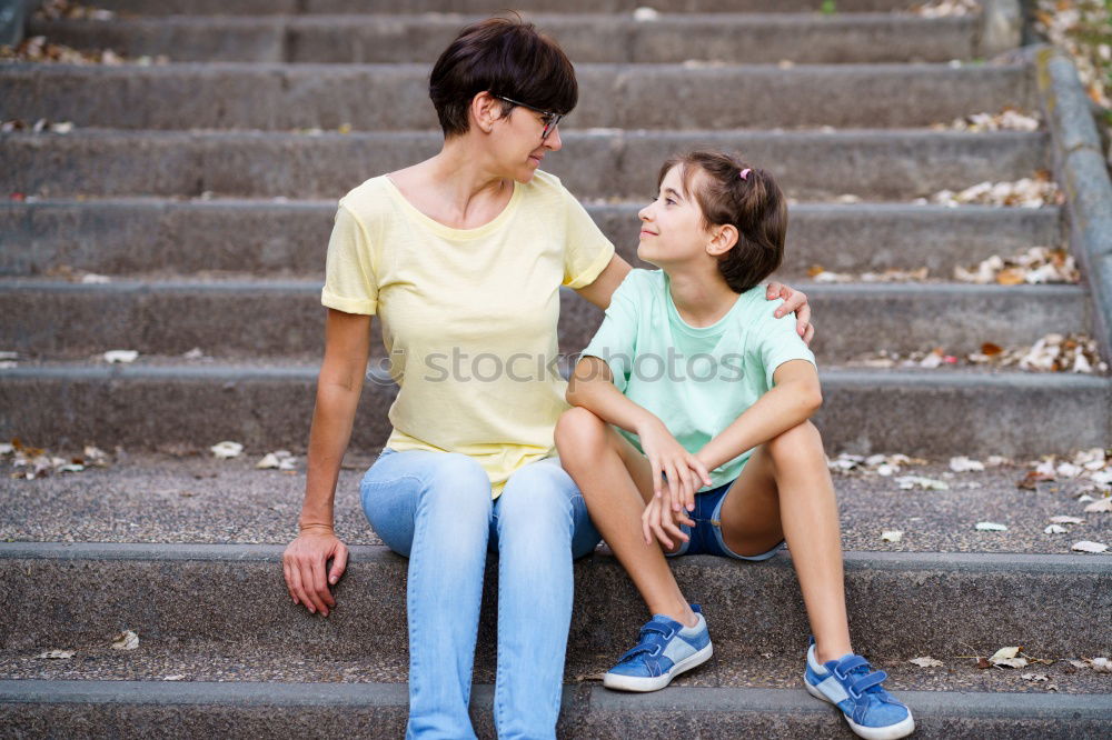 Similar – Sad mother and daughter sitting on bench in the park at the day time.