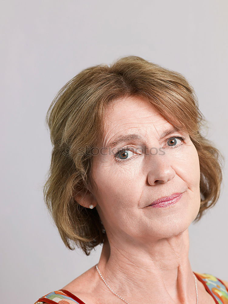 Similar – Portrait of an elderly woman with long red hair, looking mischievously to the side, with red jacket, black shirt and colourful necklace