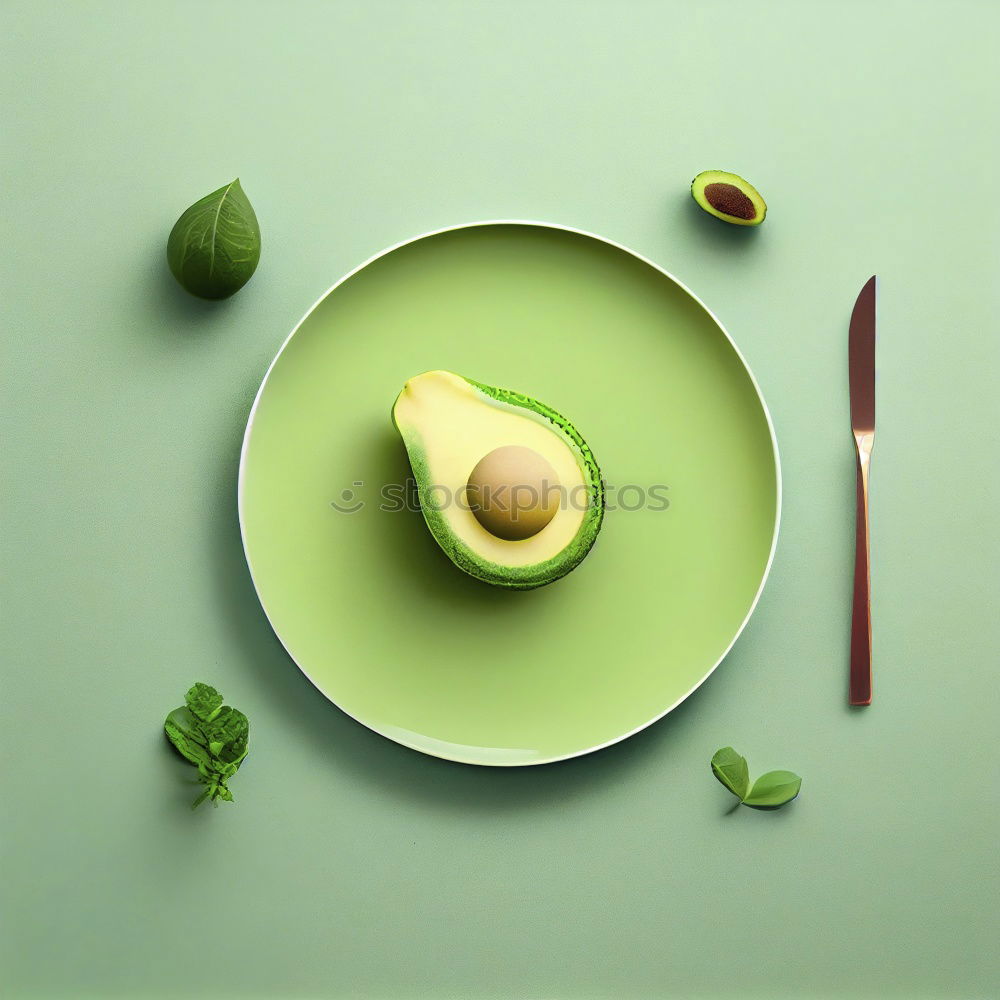 Cut avocado on white plate on pastel background