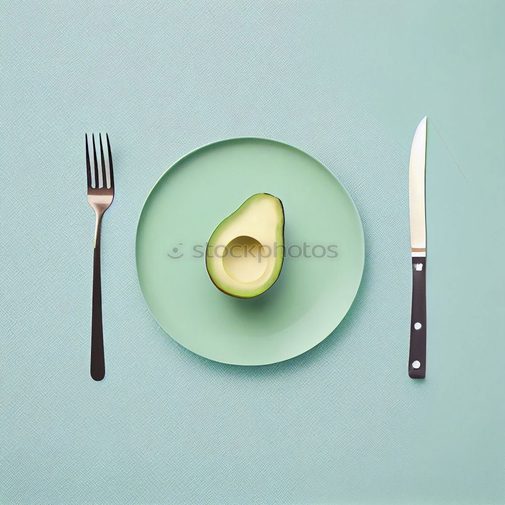 Similar – Cut avocado on white plate on pastel background