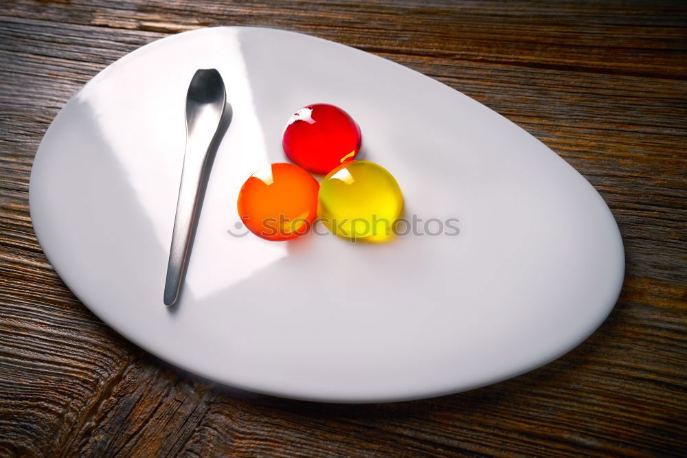 Similar – Image, Stock Photo To the point! A plate with a blue rim, on it many green and a blue ball, dots and a fork on a wooden table