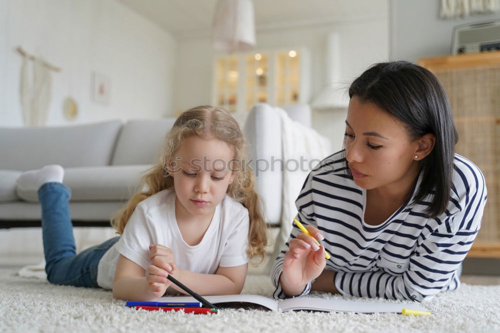 Similar – Image, Stock Photo Girl and boy reading a book sitting on the bed