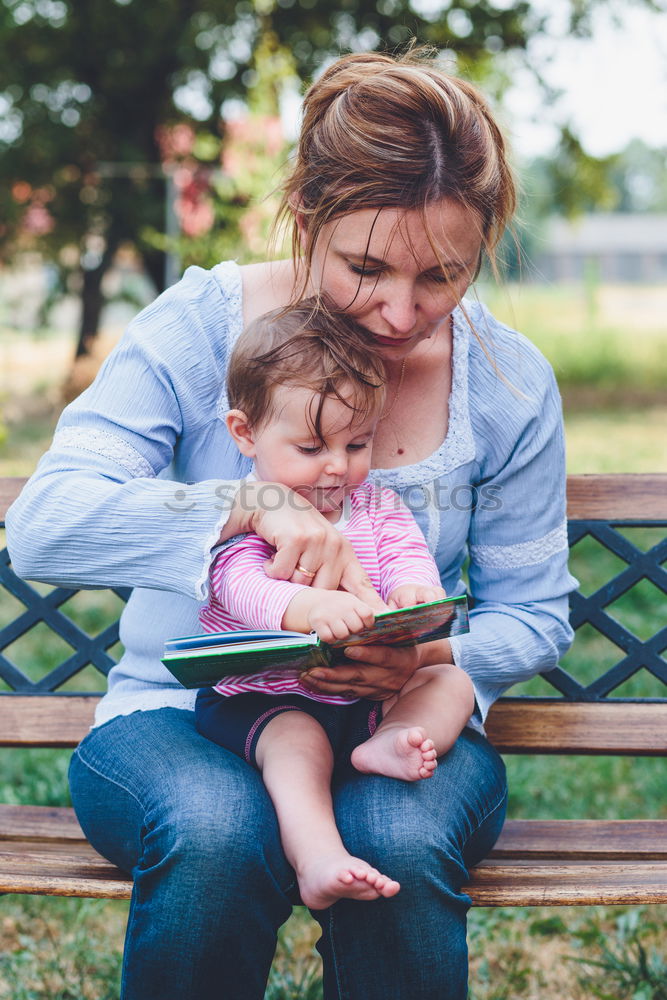 Mom reading a book her little daughter