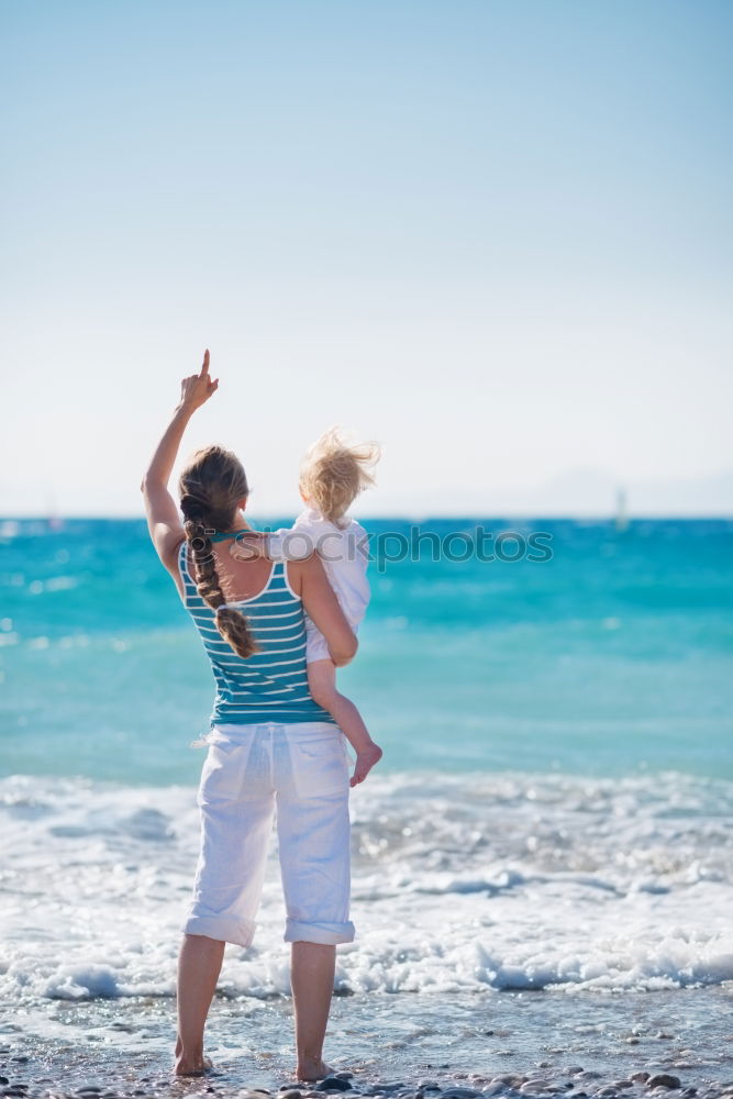 Similar – mother and son having fun with inflatable ring at beach