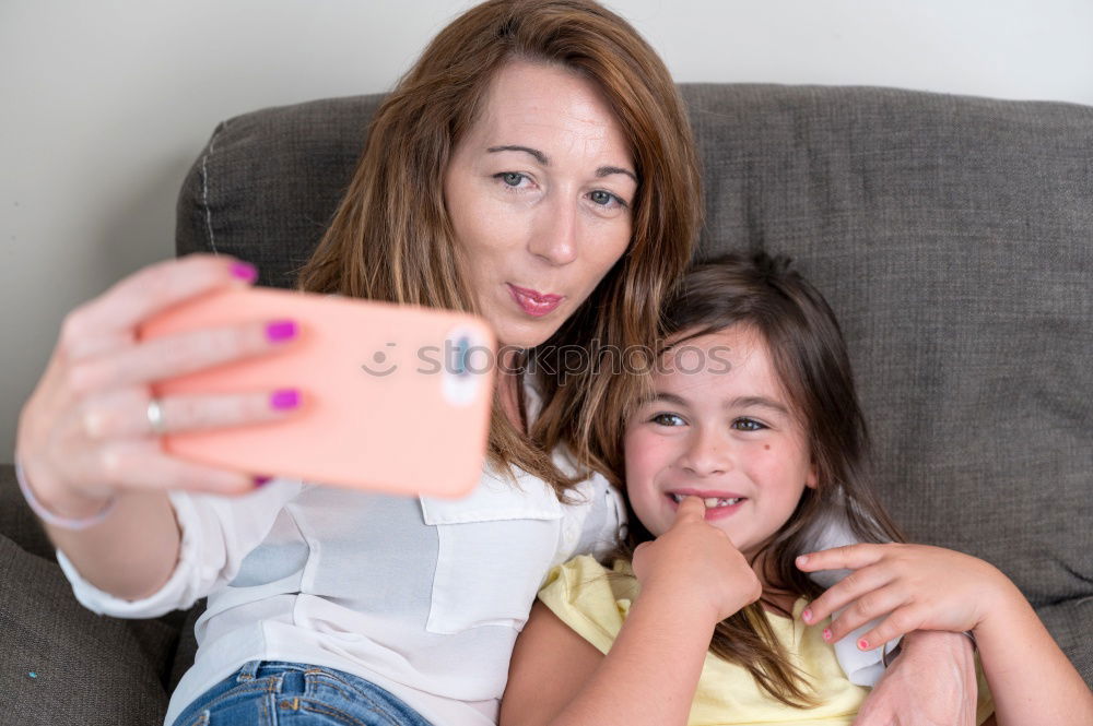 Similar – Image, Stock Photo Young women using mobile phones watching music clip, texting, messaging. Teenagers using the smartphones, sitting on sofa at home. Using technology devices. Girls wearing summer clothing