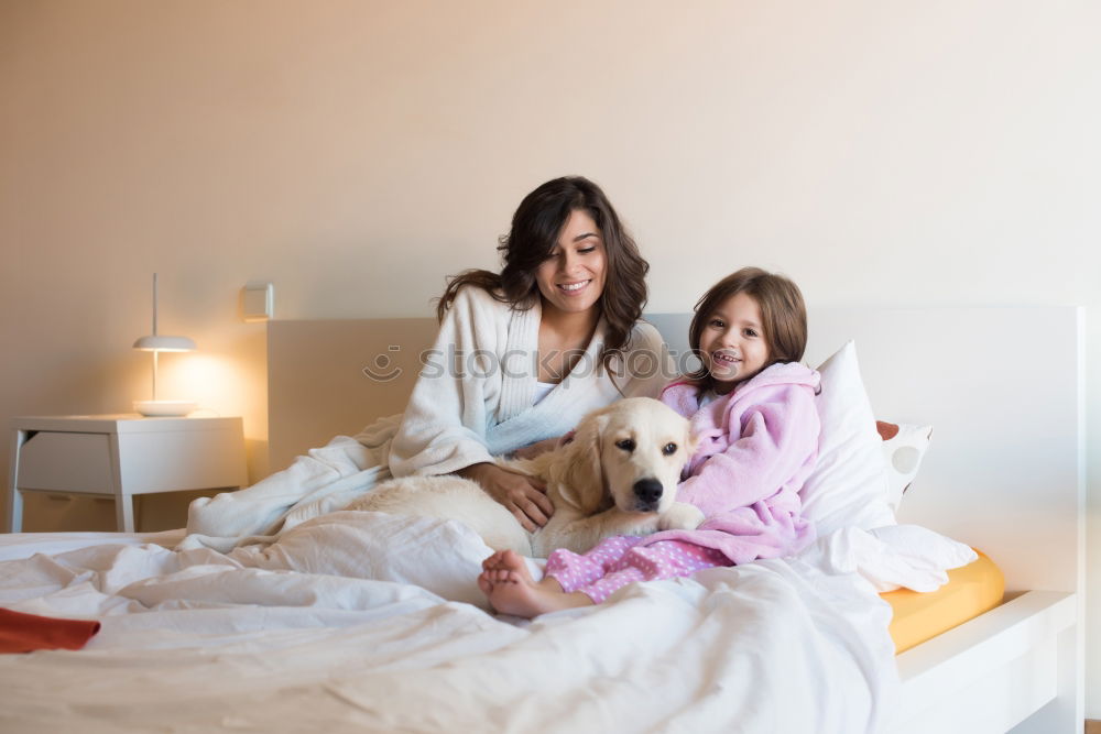 Similar – Three sisters playing with each other lying down in bed at home listening to music