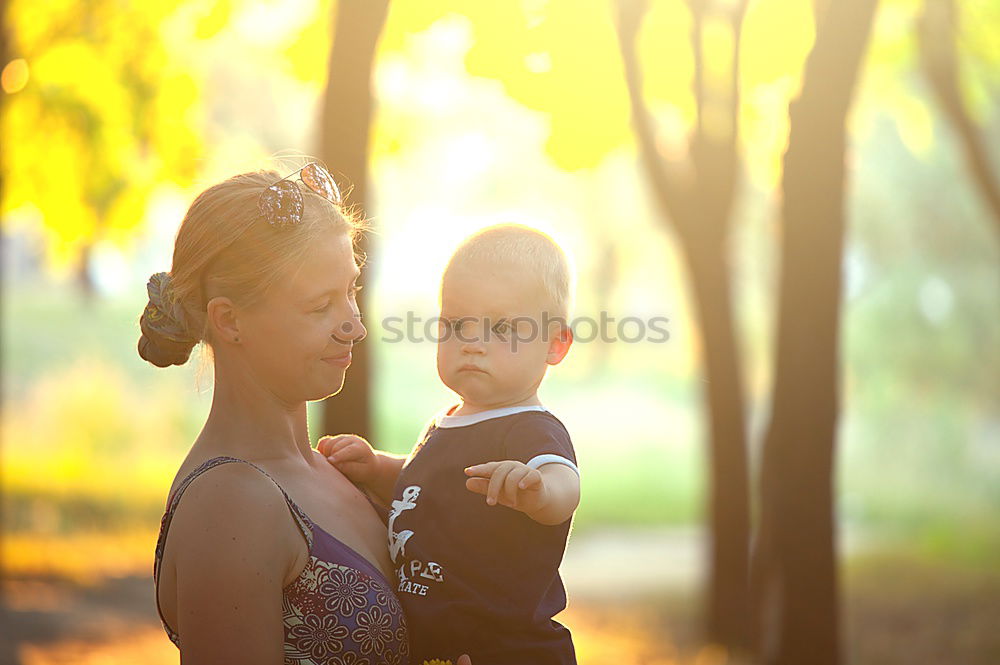 Similar – Mother holding kid on hands in park