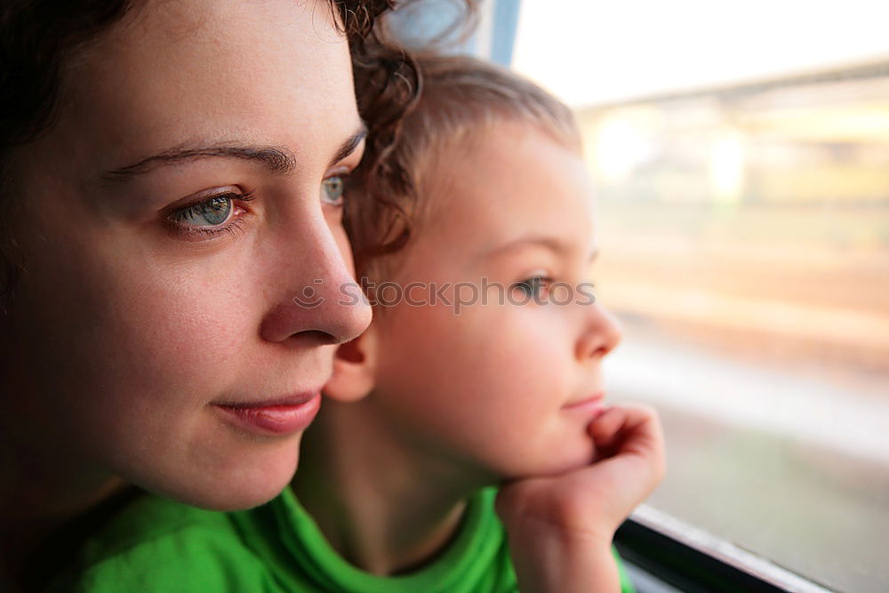 Similar – Mother and son looking through a train window as they enjoy a days travel with the small boys face reflected in the glass