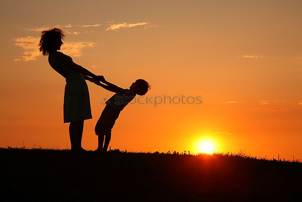 Similar – Mother and son holding hands on a beach at sunset