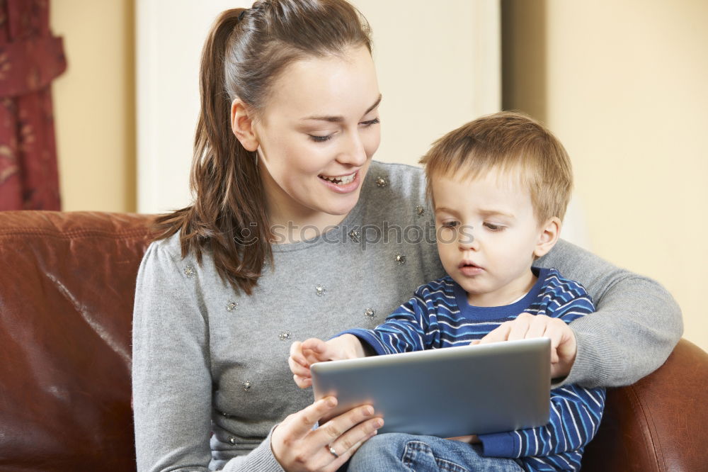 happy mother and toddler son using tablet