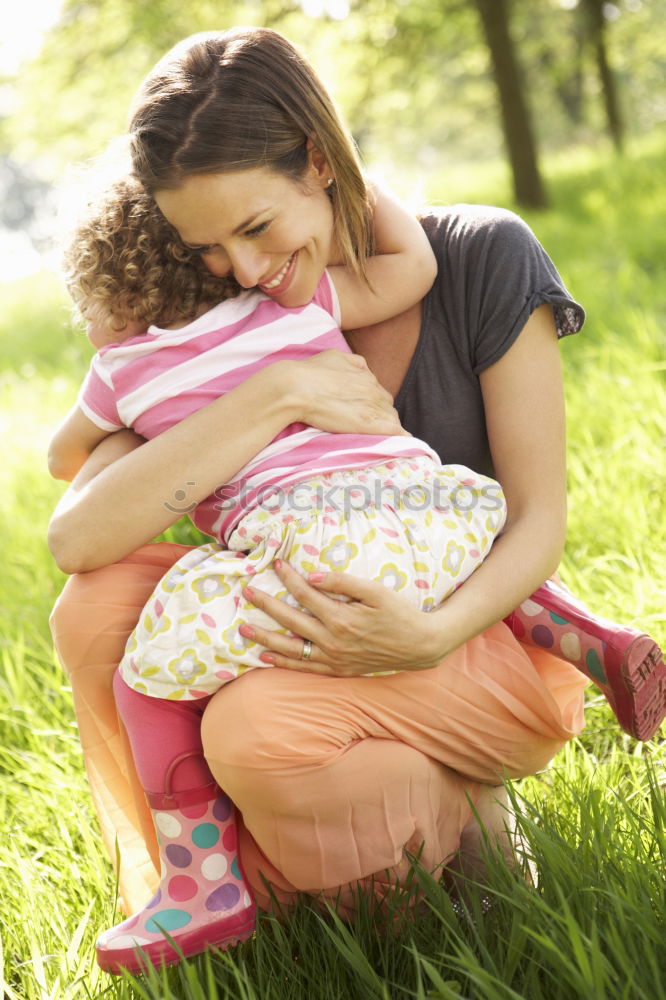 Similar – Baby girl standing on a bench hugging to woman