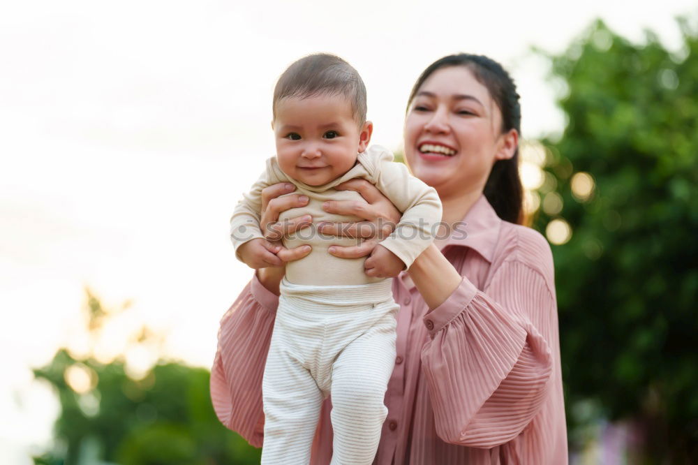 Similar – Image, Stock Photo Muslim mother holding a little baby by arms in outdoor area