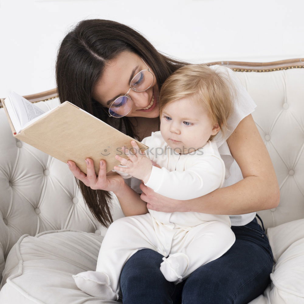 Similar – Mom reading a book her little daughter