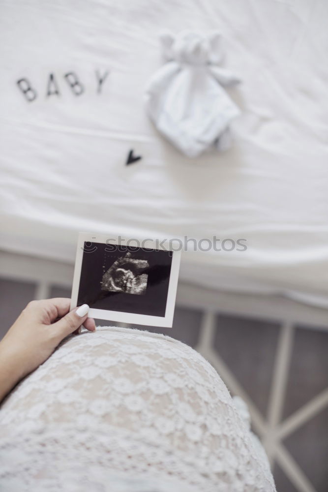 Similar – Schwangerschaftstests, Babykleidung und Ultraschalluntersuchung auf dem Bett, Ansicht von oben