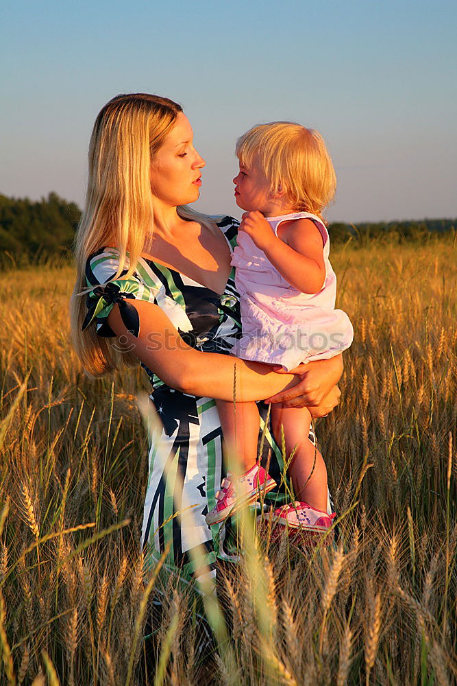 Similar – Mother holding kid on hands in park