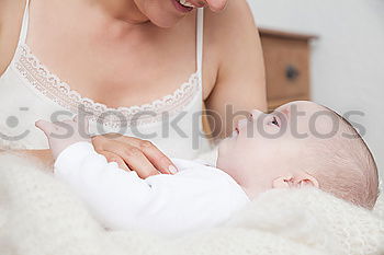 Similar – Image, Stock Photo Newborn lying on bed embraced by her mother