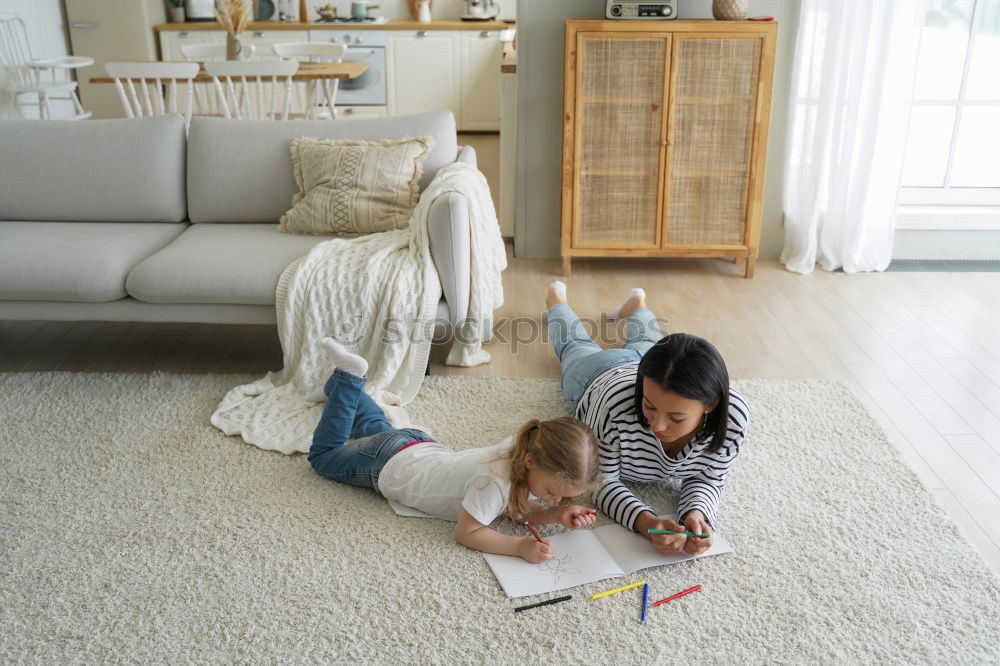 Similar – Girl and boy reading book sitting on bed