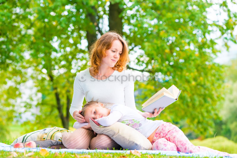 Similar – Mom reading a book her little daughter