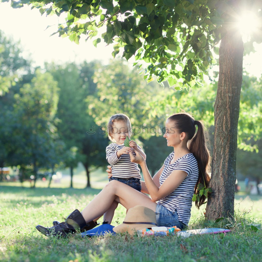 Similar – Mom reading a book her little daughter