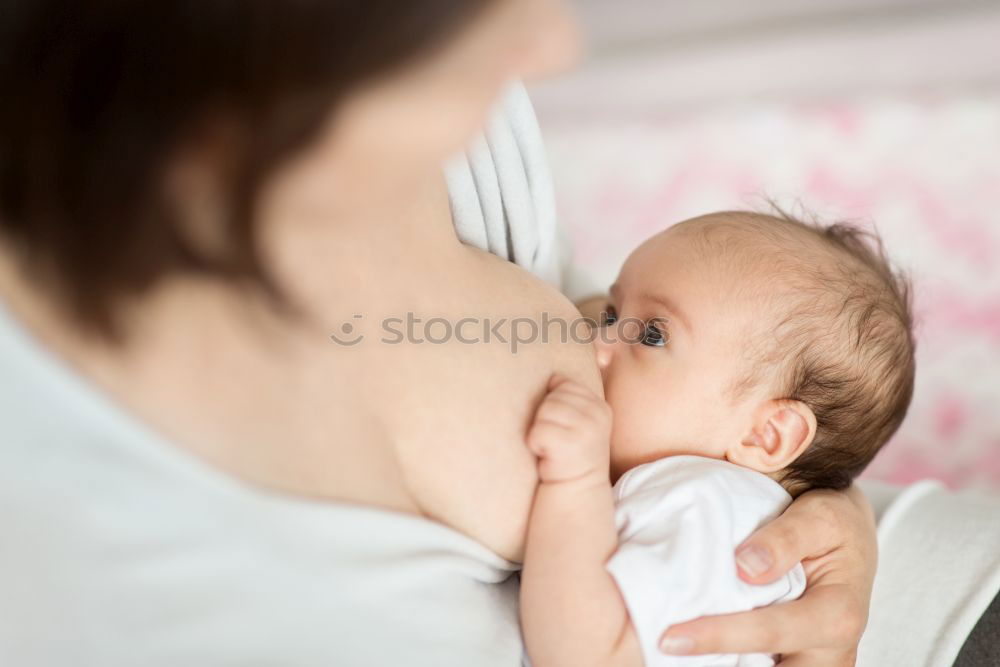 Image, Stock Photo Young mother breast feeding her baby at home