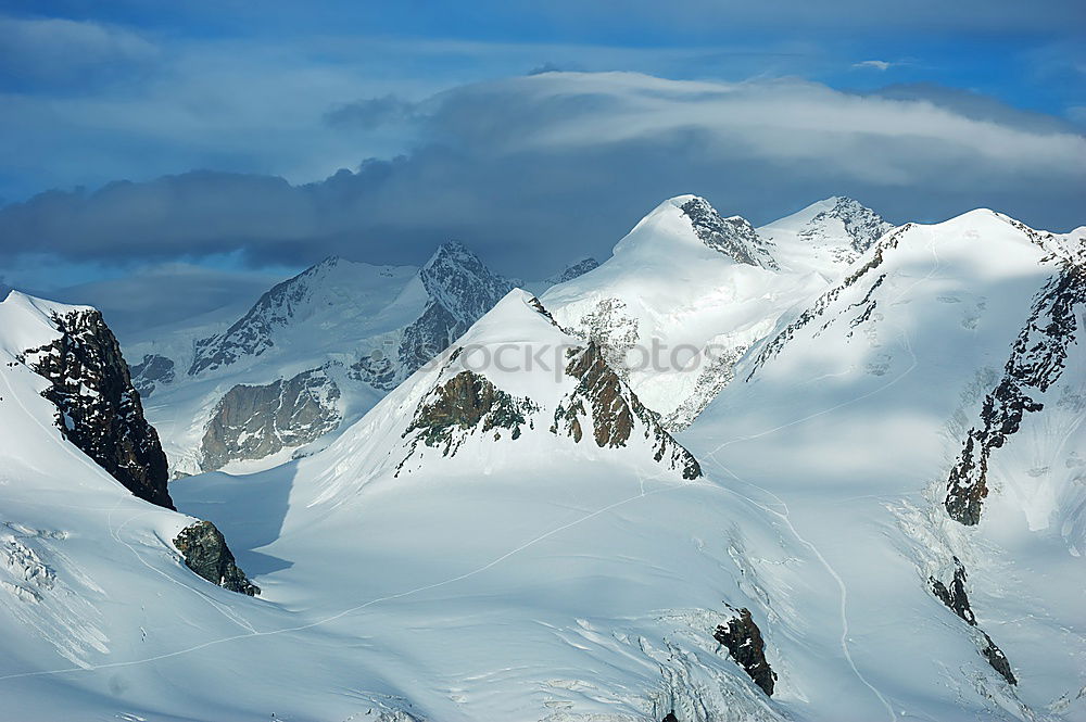 Similar – Snowy blue mountains in clouds at sunset