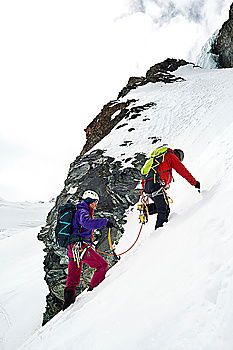 Similar – Climber helps another climber to reach the top of a mountain