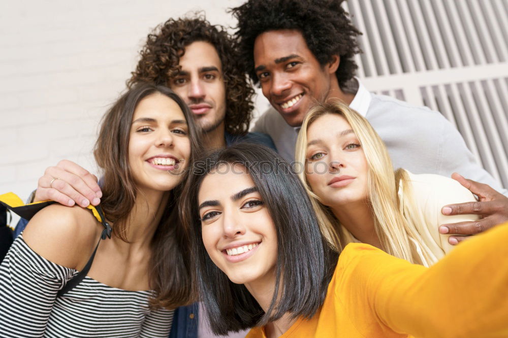 Similar – Multiracial group of friends taking selfie in a urban park