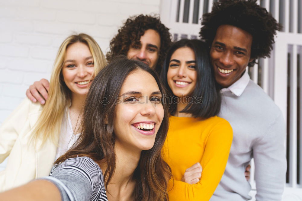 Similar – Multiracial group of friends taking selfie in a urban park