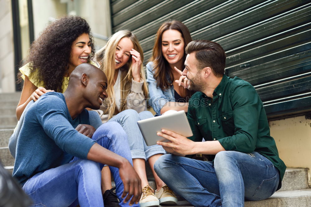 Similar – Multiracial group looking at a tablet computer outdoors