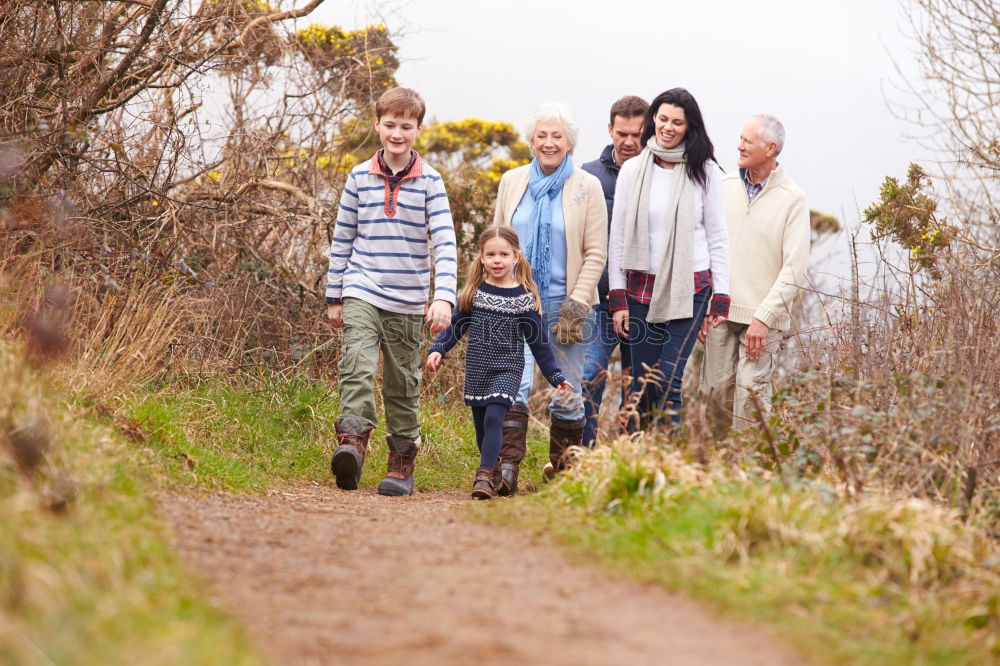 Similar – Grandparents and grandchild jumping on nature path