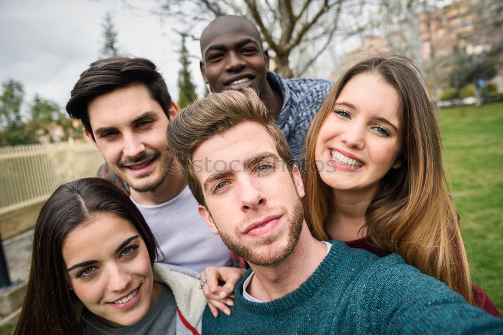 Similar – Multiracial group of friends taking selfie in a urban park