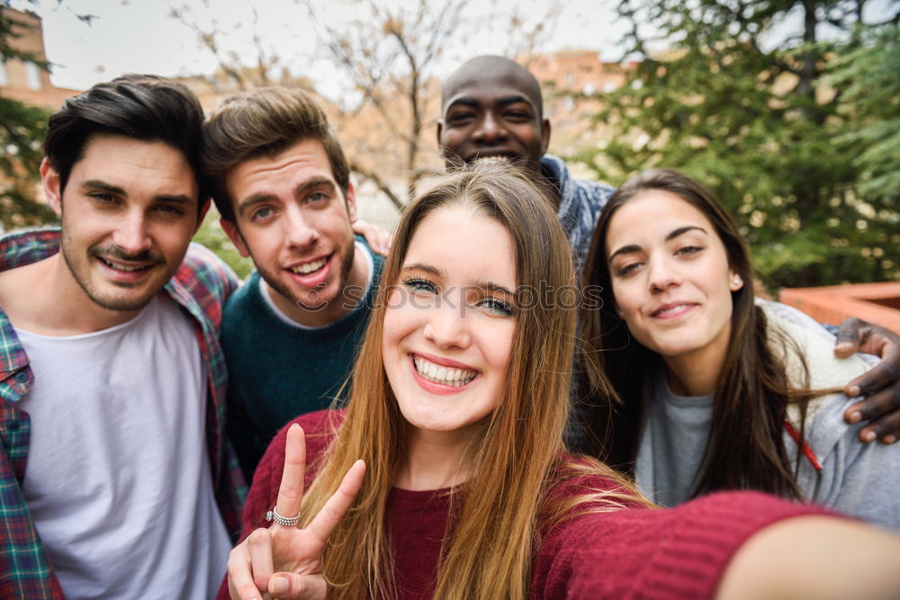 Similar – Multiracial group of friends taking selfie in a urban park