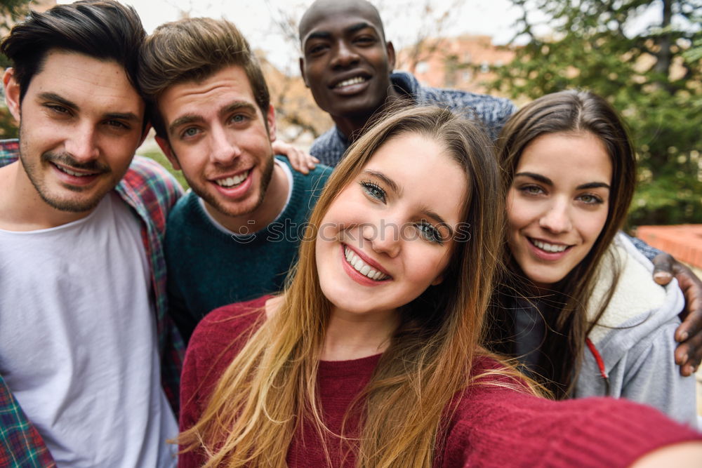 Similar – Multiracial group of friends taking selfie in a urban park