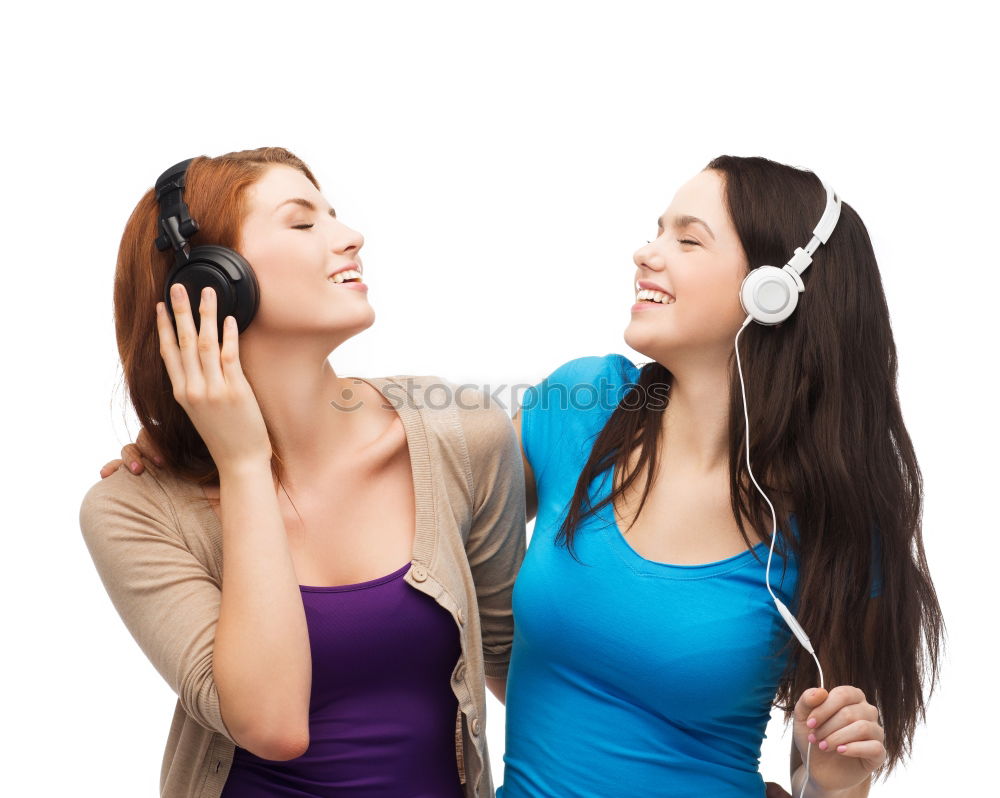 Similar – Two happy teenage girls lying on the grass sharing headphones to listen to music