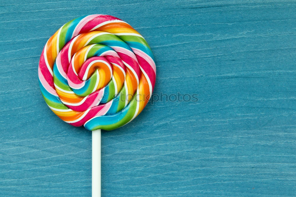 Colorful lollipop on blue background. Top view. Copyspace