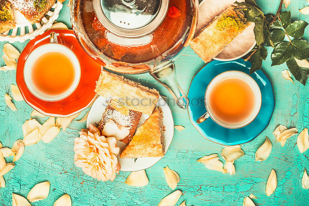 Tea brunch with coloured teacups, teapot and cake