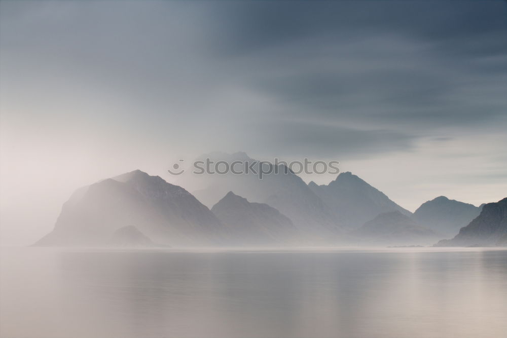 Similar – Coast of Norway sea in clouds of haze. Beacon on a rock