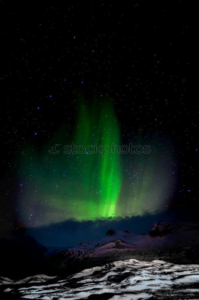 Northern lights before mountain silhouette