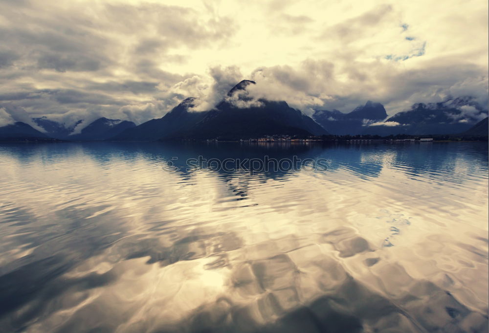 Similar – Coast of Norway sea in clouds of haze. Beacon on a rock