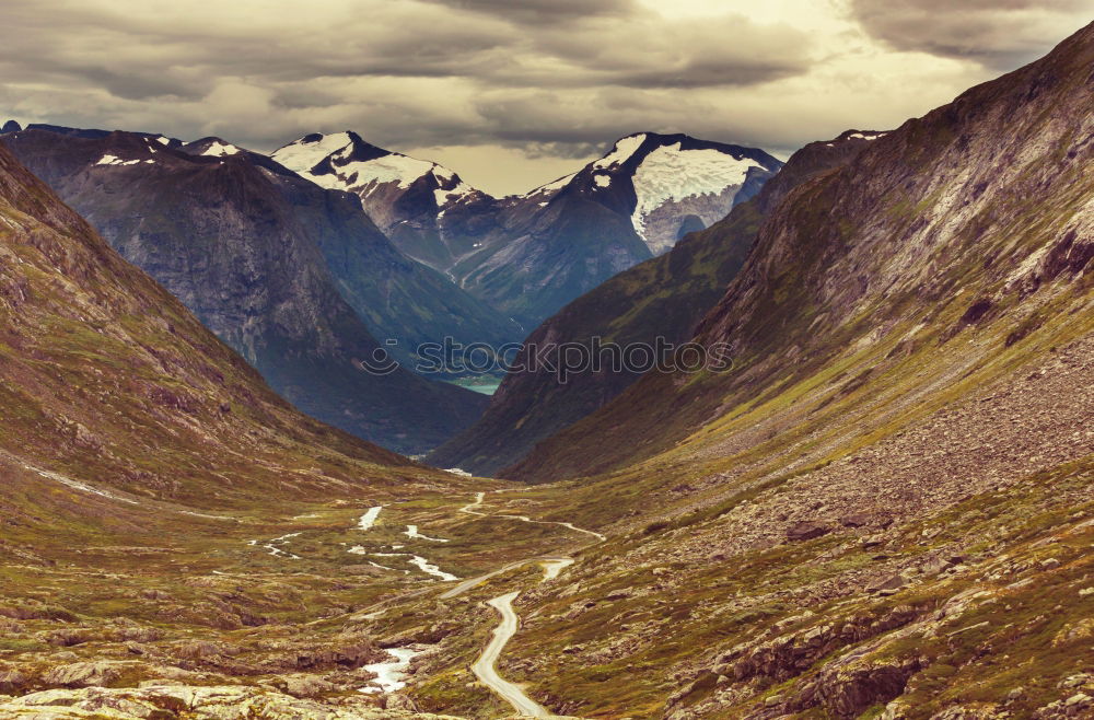 Similar – Landscape of high mountain peaks clouds and roads