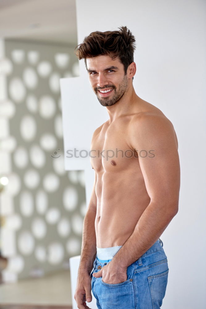 Young sexy pensive man sitting on bed