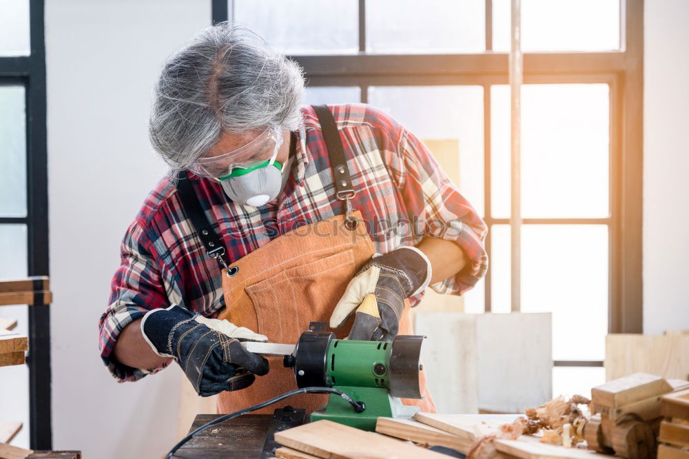 Similar – Carpenter cutting wooden board