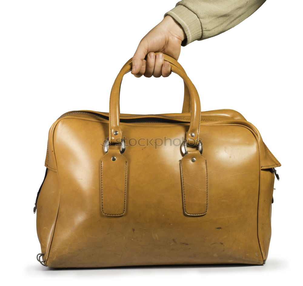 Similar – one person holds a leather travel bag in his hand